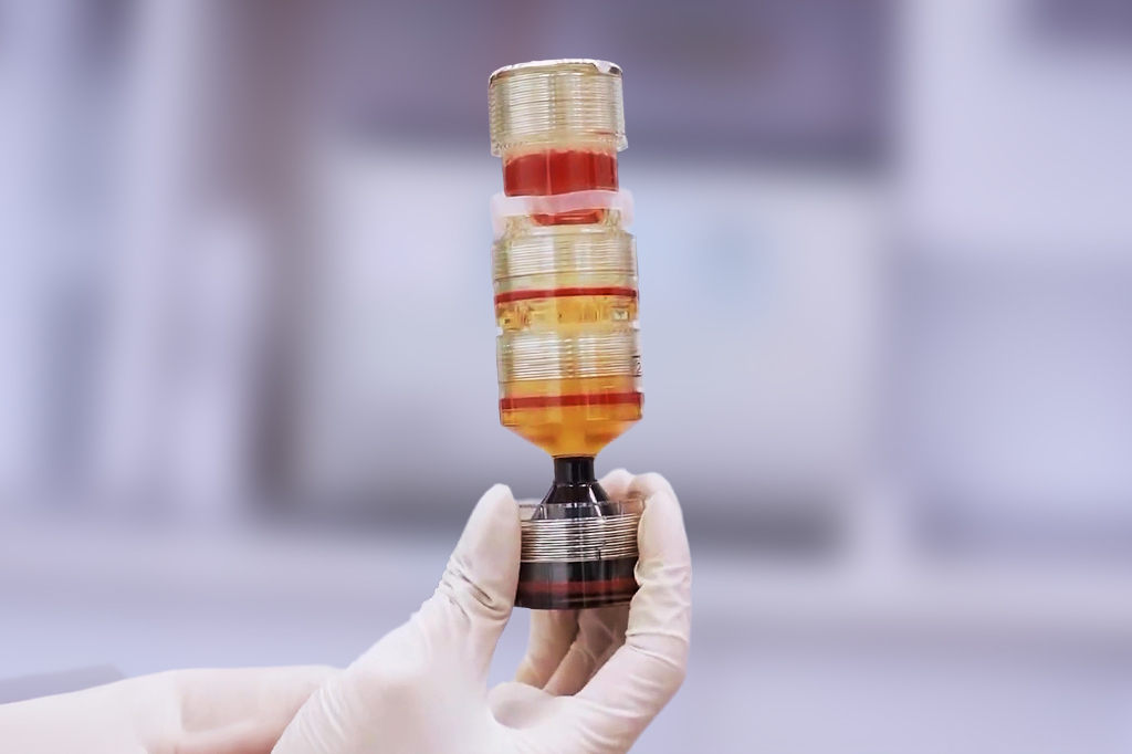 . A person holding a small bottle with a tube, showcasing a potential product or sample for demonstration.